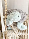 A plush turtle security blanket made by ClaraLoo with soft green and gray faux fur.