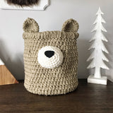 A crocheted bear basket. This basket is tan and cream colored with a black nose.